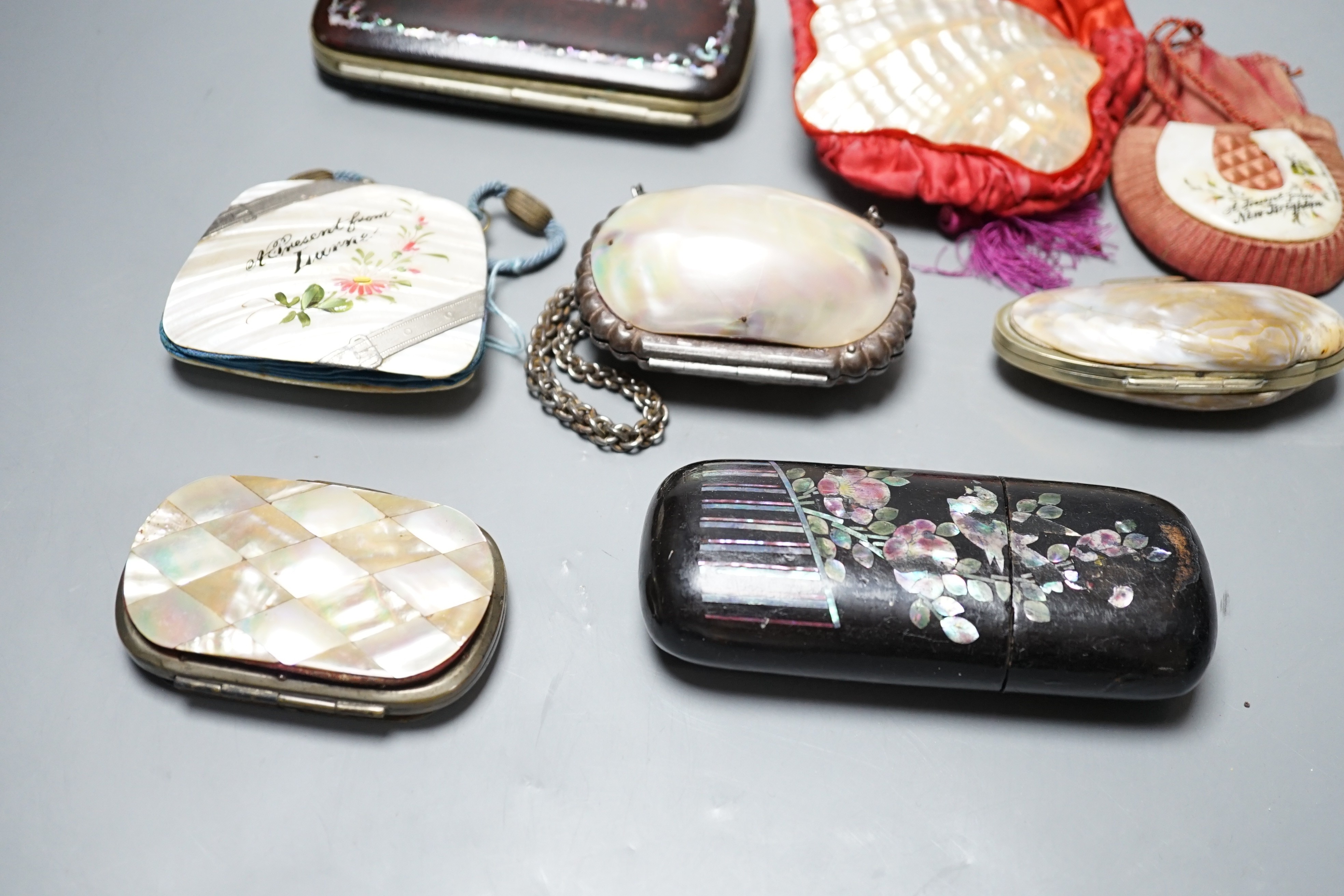 A collection of six mother of pearl souvenir purses, possibly from a grand tour and a papier-mâché mache card case and glasses case, card case 14 cms wide